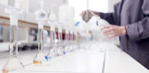 Person working in a lab, holding a beaker